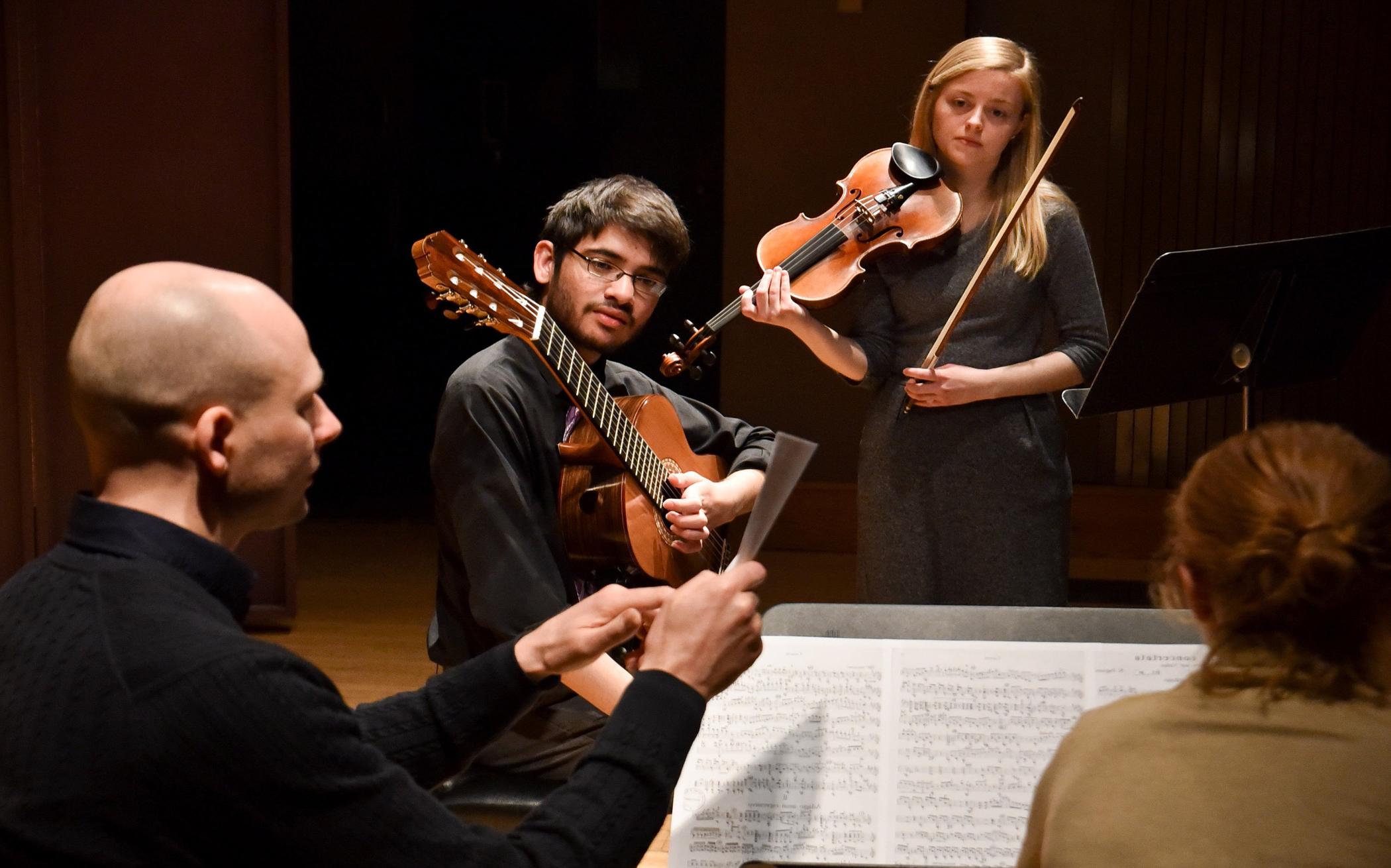 violinist and guitarist engaging in music discussion